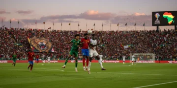 Dynamic action shot from an AFCON qualifier, showcasing player intensity and fan excitement.