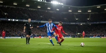 Midfielder executing a tactical foul to halt an attacking player during a football match.